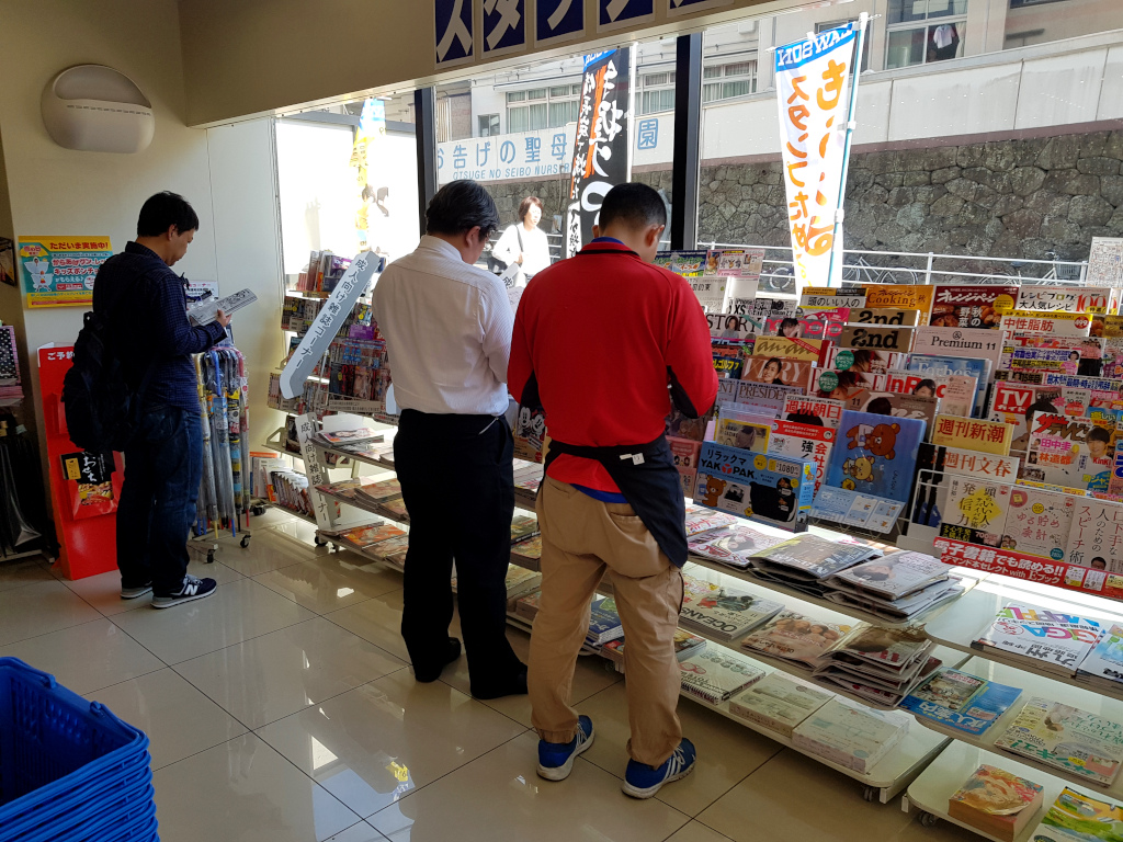 Men reading manga in a convenience store in Nagasaki, Japan